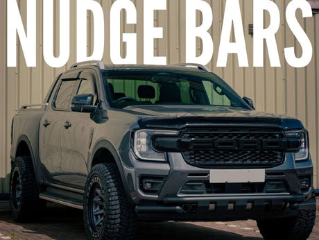 A black pickup truck showcasing aftermarket accessories, including a custom grille and tires, parked in front of a building, reflecting Brute Status's unique style.