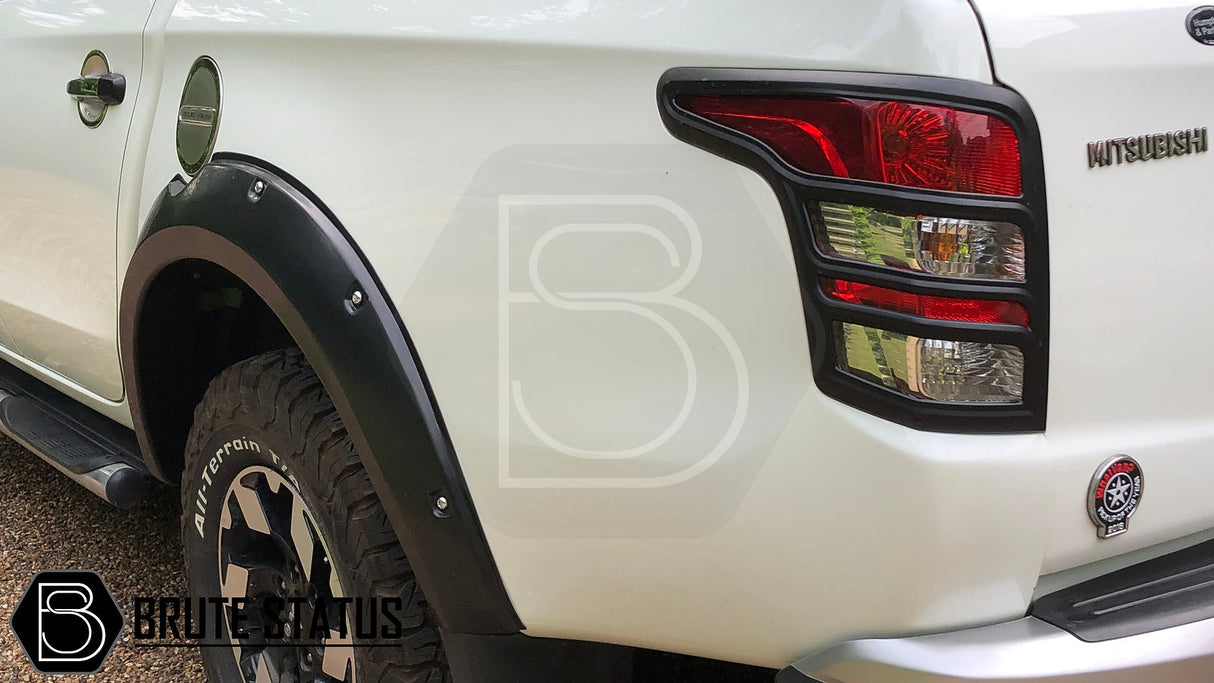 Mitsubishi L200 Series 5 2015-2019 Fender Flares installed on a truck, showcasing robust design with faux bolts and smooth black finish, enhancing vehicle style.