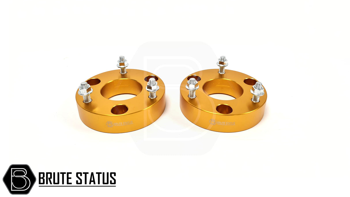 Mitsubishi L200 Series 4 B40 2005-2015 2.5 Lift Kit featuring gold metal shock spacers with bolts and nuts, designed for enhanced vehicle height and durability.