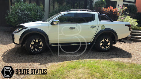 Mitsubishi L200 Series 5 2015-2019 Fender Flares showcased on a white truck, highlighting their robust, wide design and smooth black finish.