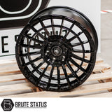 Spartan SW5 Wheels, black rim, showcased on a wooden surface, highlighting its sleek design and intricate detailing in a close-up view.