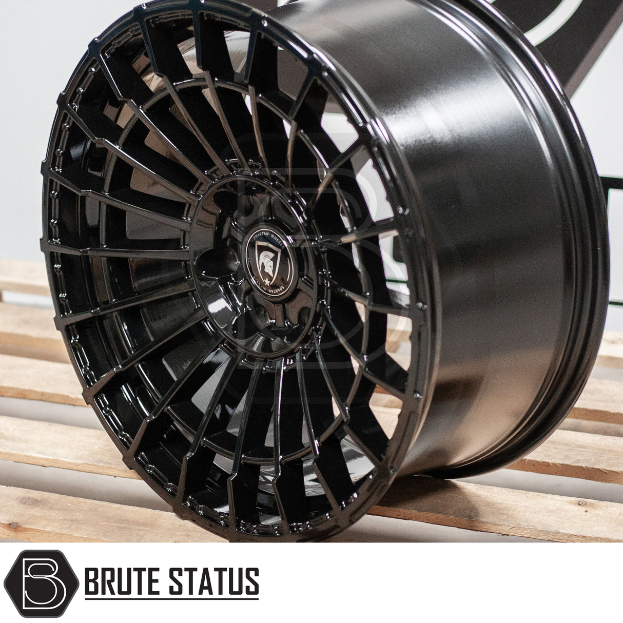 Spartan SW5 Wheels on a wooden surface, featuring a black rim with a logo, designed for customization and style in pick-up trucks.