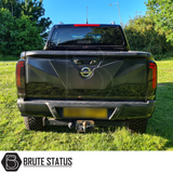 Nissan Navara NP300 2015-2022 Tailgate Cladding Cover/Protector in matte black, featuring high durability ABS plastic for damage protection, shown on a parked black truck.