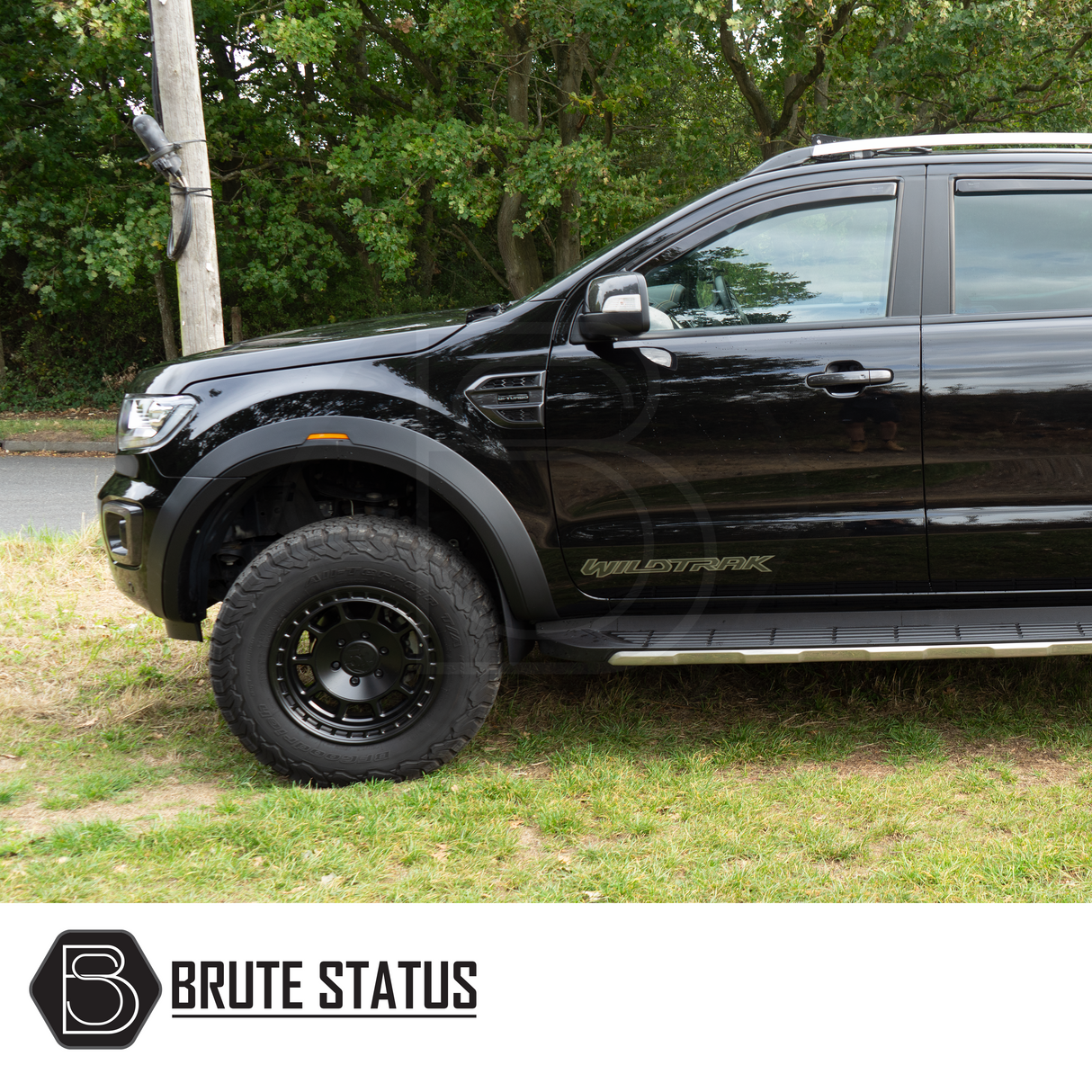 Ford Ranger 2015-2022 Wide Arch Kit (OEM Style) installed on a black SUV parked on grass, showcasing sleek, durable ABS wheel arches with a smooth black finish.