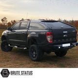 Ford Ranger 2023+ Heavy Duty S32 Steel Side Steps in matt black, robust design, shown on a parked black truck with visible tires and tail light.