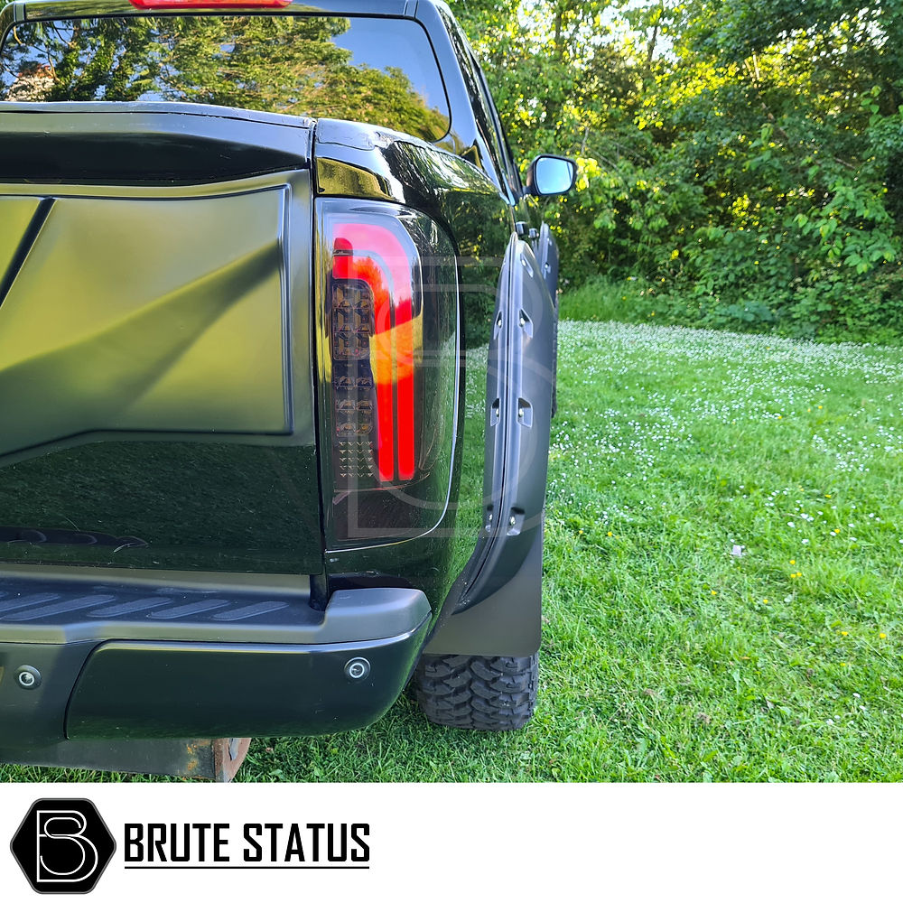 Nissan Navara NP300 2015-2022 LED Tail Lights on a black truck parked on grass, showcasing sleek aftermarket design and compatibility with existing fixtures.