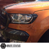 Ford Ranger 2015-2022 T7 T8 Head Light Covers in Gloss Black, enhancing a bold, aggressive look with water droplets highlighting its sleek design.