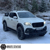 Mercedes X-Class AMG Panamerica Style Front Grille in gloss black, showcased on a snow-covered white truck, highlighting its sleek, aftermarket design for enhanced vehicle aesthetics.