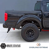 Nissan Navara D40 2005-2010 Overland Extreme Wide Arch Kit on a black truck, showcasing large tires and durable ABS plastic wheel arches for enhanced customization.