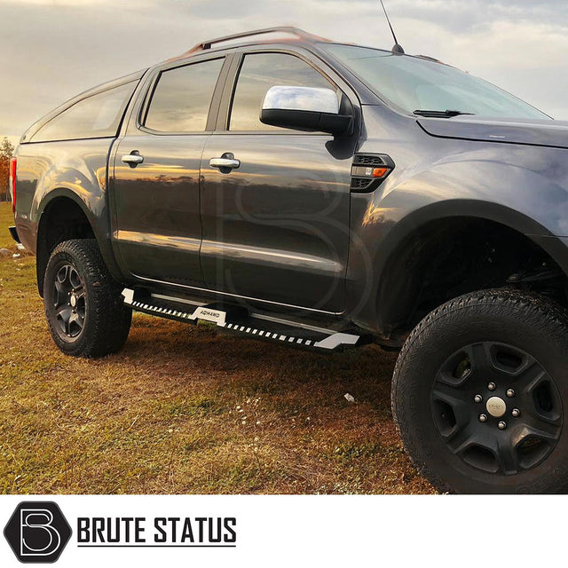 Mitsubishi L200 Series 5 2015-2019 Heavy Duty S32 Steel Side Steps in matt black, shown installed on a parked vehicle, highlighting durability and design.