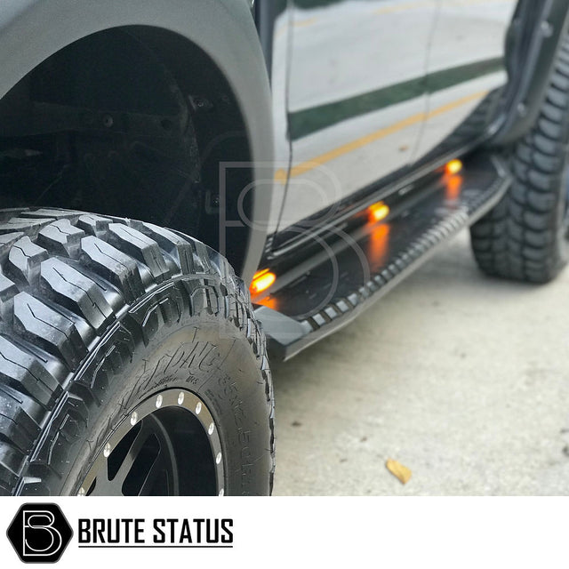 Mitsubishi L200 Series 5 2015-2019 Heavy Duty S30 Steel Side Steps with LEDs, showcasing close-up of black truck tire and LED integration.