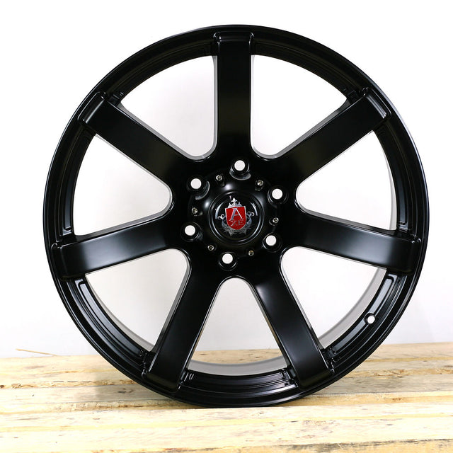 AXE Wheels Quake in Matt Black, showcasing a close-up of the alloy wheel rim with a distinctive red logo, highlighting its design and craftsmanship.