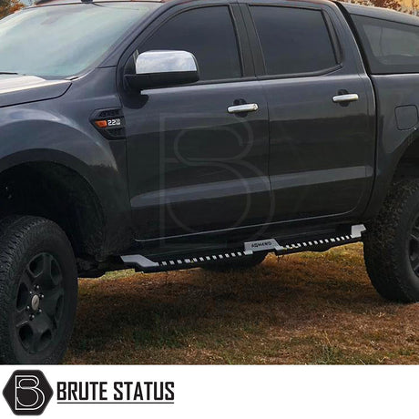 Volkswagen Amarok 2010-2017 Heavy Duty S32 Steel Side Steps, matt black finish, shown on a black truck parked on grass, highlighting durability and design.