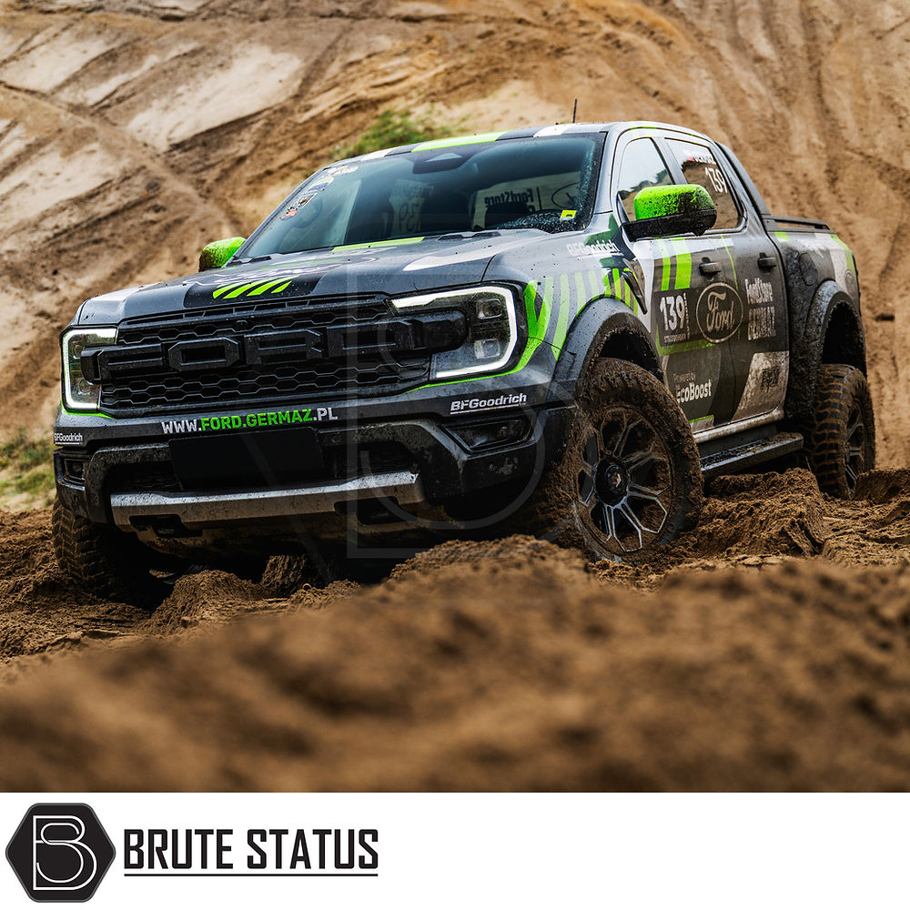 JR Wheels JRX11 on a black and green truck driving through mud, highlighting the rugged tire design and off-road capability.