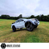 Ford Ranger 2012-2019 2 Inch Lift Kit displayed on a white truck, highlighting shock spacers and rear lift shackles positioned outdoors on grass.