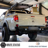 Mitsubishi L200 Series 4 2006-2009 Wide Arch Kit (Overland Extreme) displayed on a white truck in a garage, showcasing premium ABS plastic wheel arches.