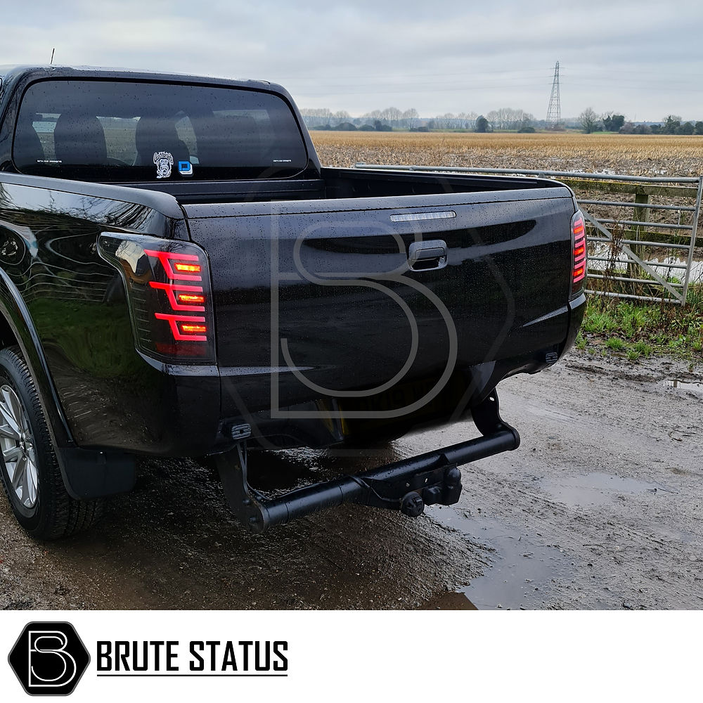 Mitsubishi L200 2015-19 LED Tail Lights, aftermarket, clear lenses with white accents, designed for easy installation, enhance pickup truck's style and visibility.