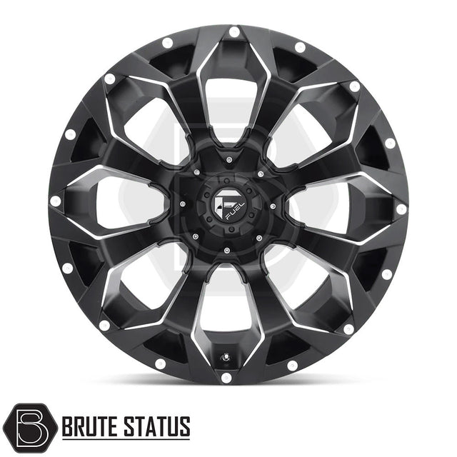 Fuel Assault Wheels in Matte Black Milled, featuring a distinctive black rim with white text and stripes, designed for pickup truck customization.