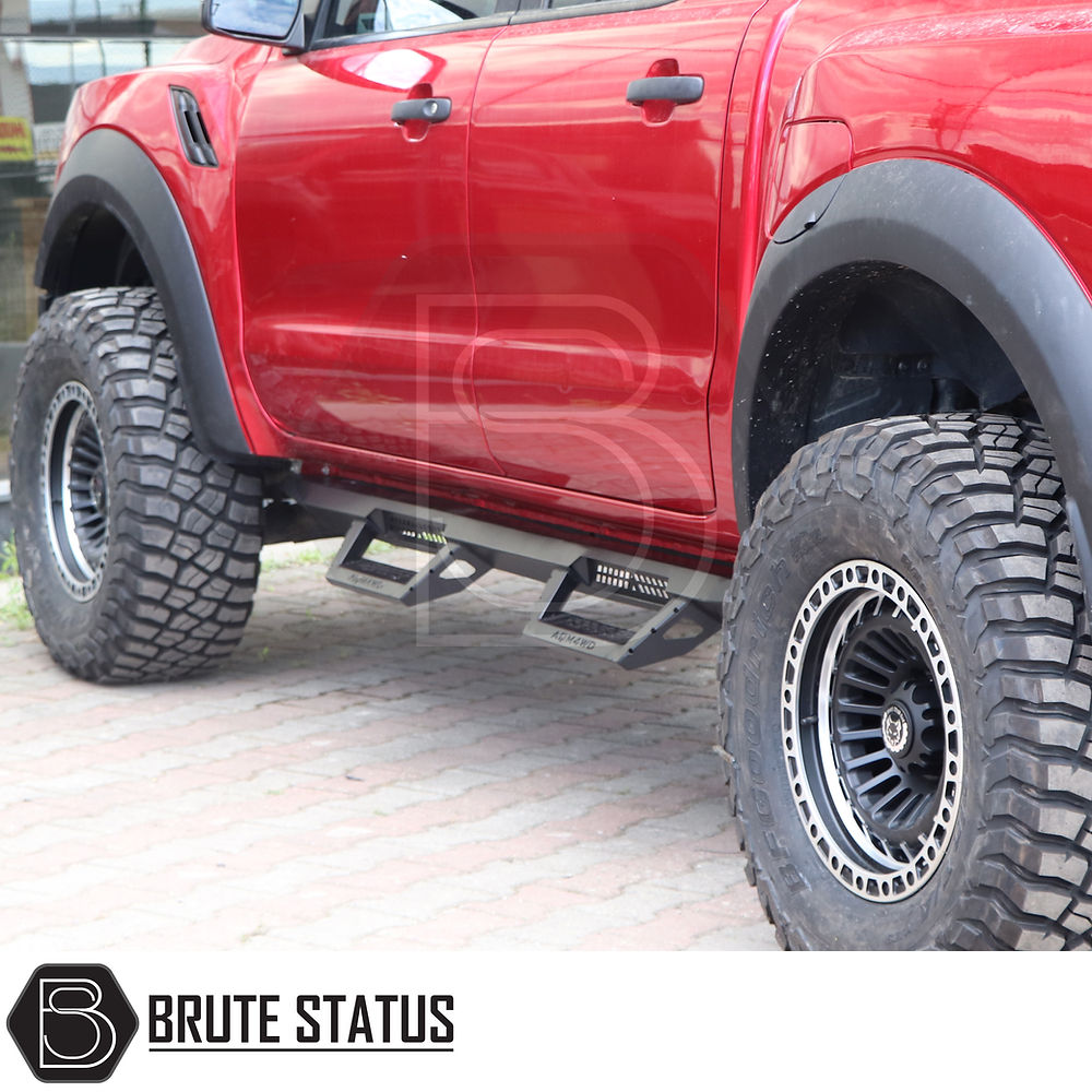 Toyota Hilux 2015+ Heavy Duty T32 Steel Side Steps, visible on a red truck with large tires, designed for durability and protection.